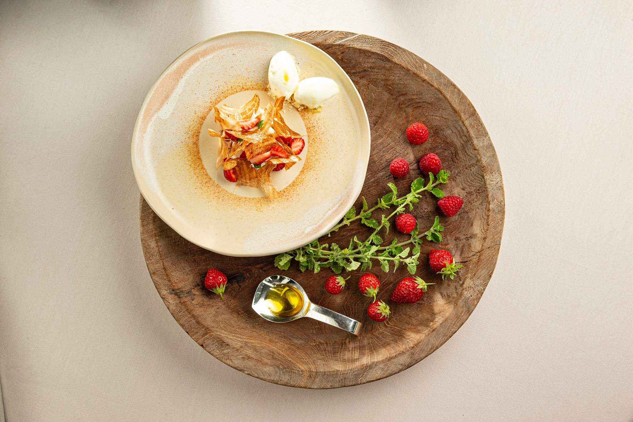 Restaurant gastronomique présentation raffinée de dessert crémeux aux framboises et œuf poché