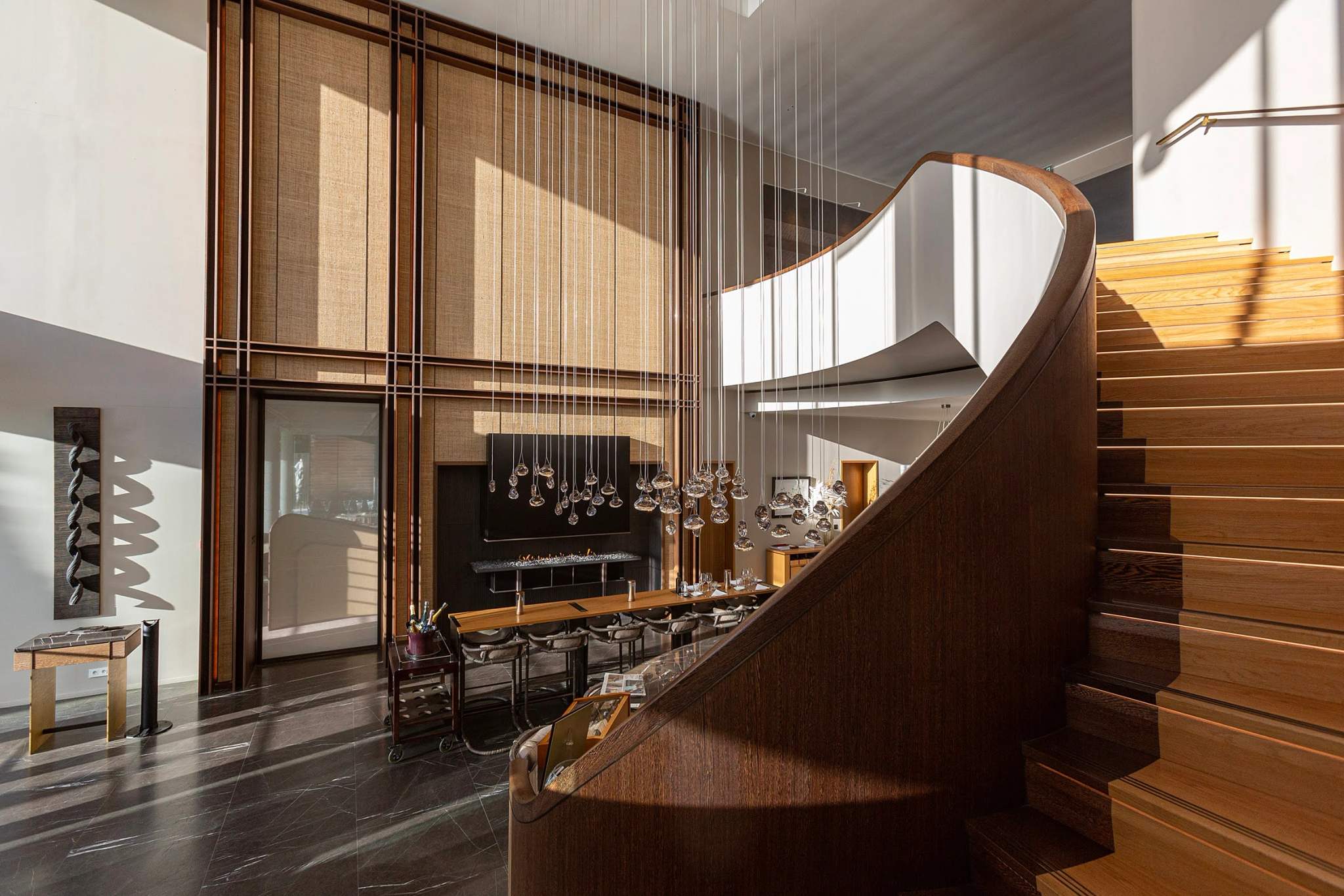 Escalier en bois d'un hôtel 5 étoiles avec lustre et baies vitrées