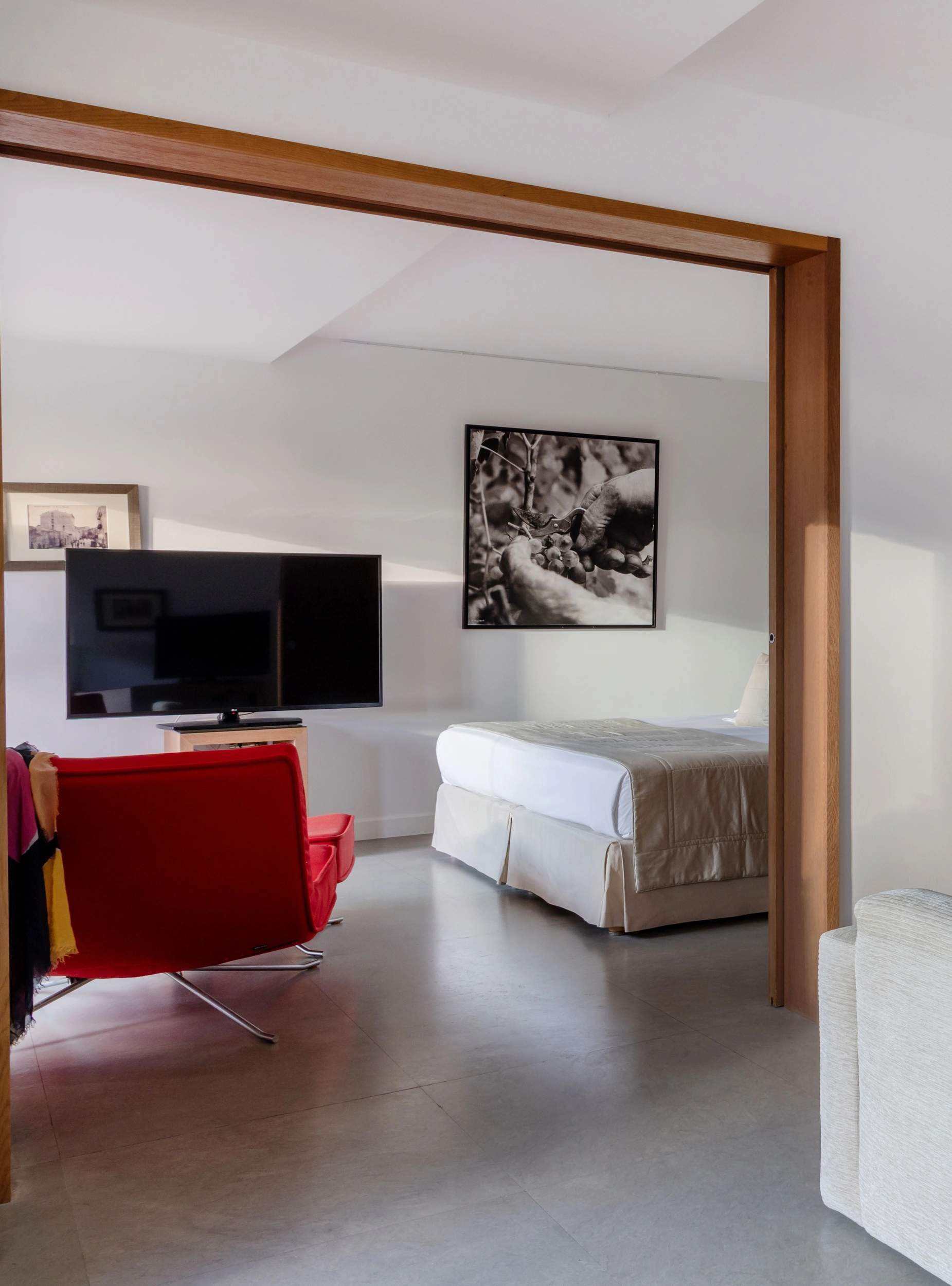 Chambre d'hôtel de luxe moderne avec lit, fauteuil rouge et télévision